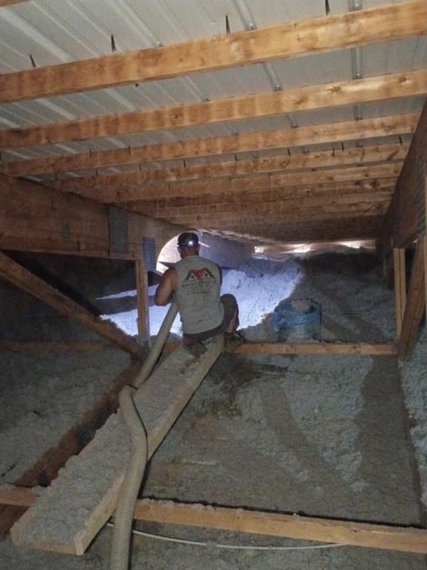 Right Choice Energy installer blowing loose-fill insulation across an attic floor with a hose